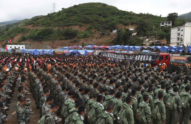 Nhân viên cứu hộ và người dân dành một phút mặc niệm cho các nạn nhân thiệt mạng trong trận động đất ở tỉnh Vân Nam, Trung Quốc.