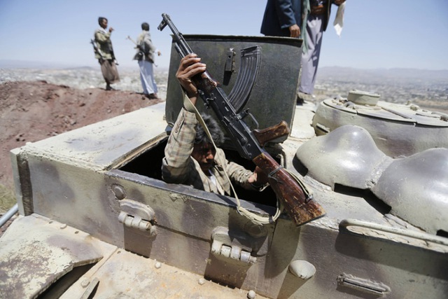 Chiến binh phiến quân trèo vào một chiếc xe của quân đội Yemen sau khi phe phiến quân chiếm một căn cứ quân sự ở thủ đô Sanaa.