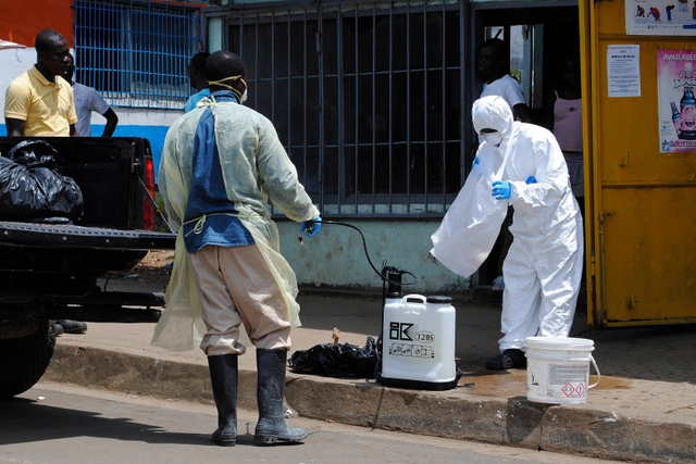 Đội chôn cất nạn nhân tử vong do nhiễm virus Ebola đang tẩy uế ở Monrovia, Liberia.