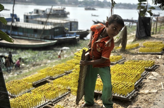 Cậu bé làm việc tại một nhà sản xuất bóng bay ở Dhaka, Bangladesh.