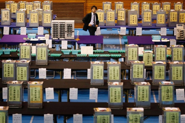 Một quan chức bầu cử đứng giữa các hòm bỏ phiếu trong cuộc bầu cử quốc hội ở Tokyo, Nhật Bản.