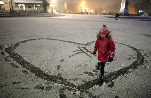 Bé gái thể hiện tình yêu trên tuyết ở Warsaw, Ba Lan.