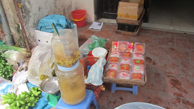  Một sạp bánh Trung thu không rõ nguồn gốc bán lẫn với dưa cà tại chợ Khâm Thiên. Loại bánh này thường được sản xuất tại một số cơ sở nhỏ lẻ và không ghi rõ nguồn gốc trên bao bì.