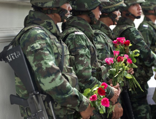 Các binh sĩ Thái Lan cầm hoa hồng do những người ủng hộ quân đội đảo chính tặng tại một căn cứ quân sự ở Bangkok.