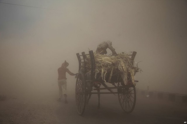 Hai người đàn ông cùng xe ngựa đi trong bão cát ở thành phố Jammu, Ấn Độ.