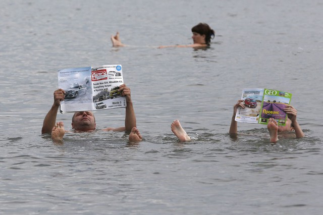 Một cặp đôi đọc báo khi họ nằm nổi trên hồ Tus ở Khakassia, Nga. Hồ Tus có nồng độ muối rất cao khiến mọi người dễ dàng nổi trên mặt nước.