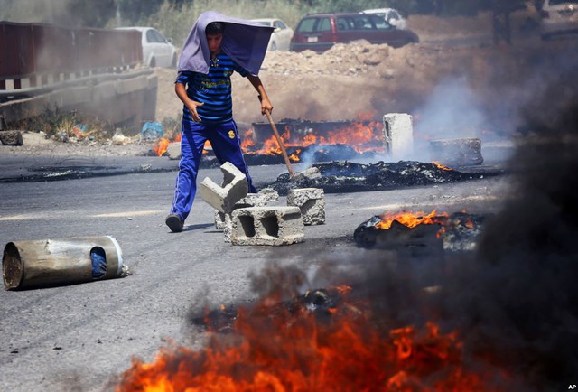 Một thanh niên người Kurd chặn đường trong cuộc biểu tình phản đối khủng hoảng nhiên liệu ở Irbil, Iraq.
