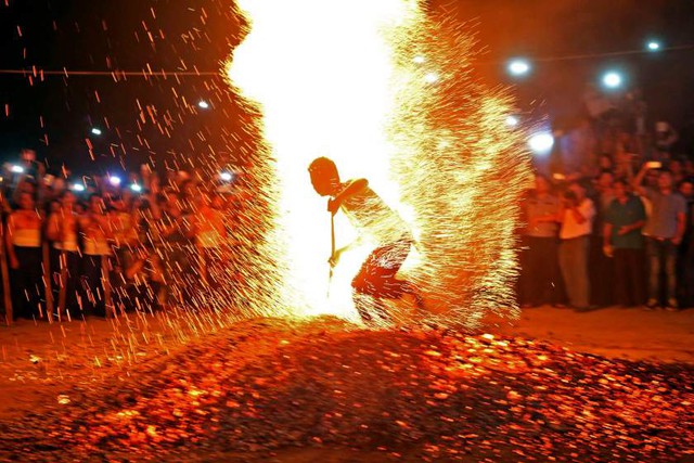 Một người đàn ông biểu diễn chạy chân trần qua than hồng tại tỉnh Chiết Giang, Trung Quốc.