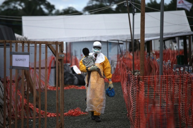 Nhân viên y tế bế em bé bị nghi nhiễm virus Ebola tại trung tâm điều trị MSF ở Paynesville, Liberia.