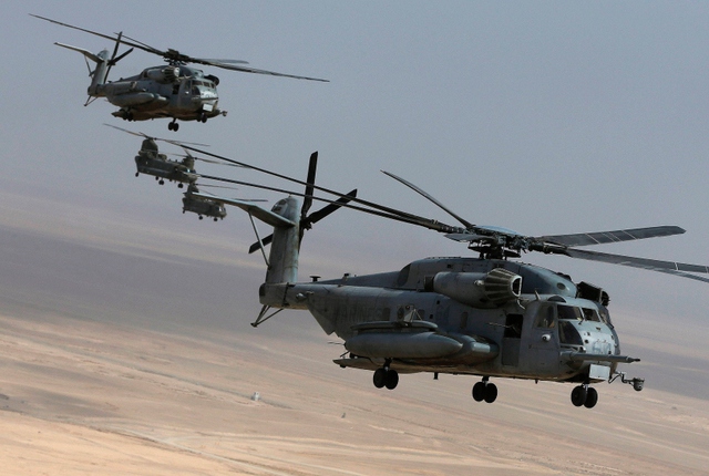 Máy bay trực thăng CH-53E và Chinook chở lính thủy đánh bộ Mỹ cất cánh từ trại quân sự Bastion ở Helmand, Afghanistan.