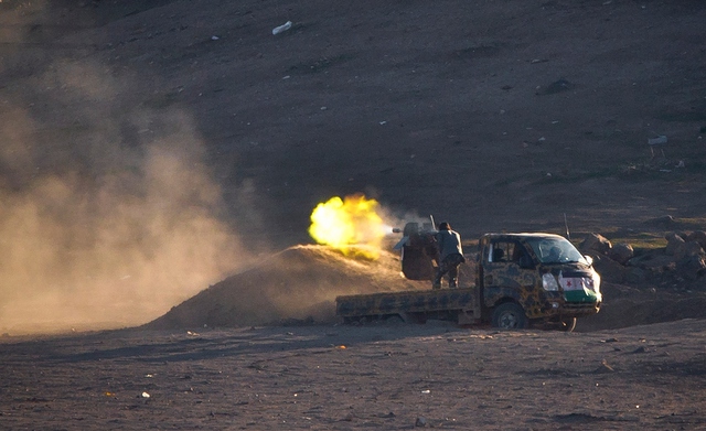 Chiến binh xả đạn từ một chiếc xe tải nhằm vào nhóm phiến quân Nhà nước Hồi giáo ở Kobani, Syria.