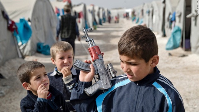 Một cậu bé người Kurd đến từ Syria cầm súng đồ chơi tại trại tị nạn ở Suruc, Thổ Nhĩ Kỳ.