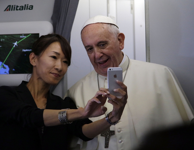 Ngày 13/8/2014, chuyên cơ của Giáo hoàng Francis xuất phát từ sân bay Fiumicino, Rome tới Hàn Quốc, với hơn 70 nhà báo đồng hành. Sau khi máy báy cất cánh khoảng 40 phút, Giáo hoàng đã có cuộc tiếp xúc thân mật trong nửa tiếng đồng hồ với các nhà báo. Trong hình, Giáo hoàng Francis chụp ảnh tự sướng cùng phóng viên Shoko Ueda của Kyodo News (Nhật Bản). Nguồn: dfic.cn