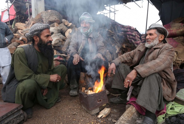 Những người đàn ông ngồi sưởi ấm quanh bếp lửa ở Herat, Afghanistan. Mùa đông ở Afghanistan rất khắc nghiệt với nhiệt độ giảm dưới 0 độ C và nhiệt độ còn giảm hơn nữa vào ban đêm.