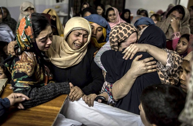 Người thân than khóc một học sinh thiệt mạng trong vụ tấn công khủng bố của nhóm phiến quân Taliban vào một trường quân đội ở Peshawar, Pakistan.