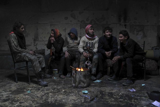 Chiến binh phiến quân Syria ngồi nghỉ ngơi trong một căn phòng tại thành phố Aleppo.