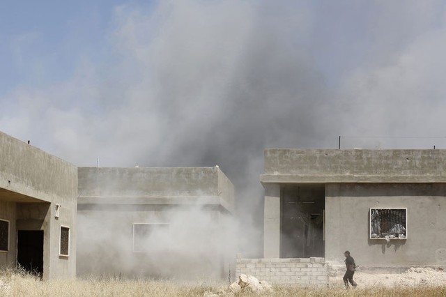 Khói bốc lên sau khi quân đội chính phủ bắn đạn pháo nhằm vào thị trấn Morek ở tỉnh Hama, Syria.
