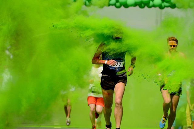 Các vận động viên chạy qua bột màu do hai người bên đường ném ra trong cuộc thi chạy Color Run 2014 tại Moscow, Nga.