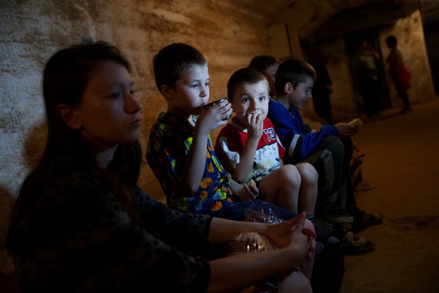 Trẻ em ngồi dưới một hầm tránh bom khi quân đội Ukraine tiến hành các cuộc không kích tại vùng Donetsk.