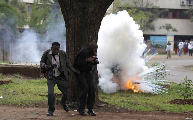Các phóng viên ảnh chạy khỏi lựu đạn hơi cay do cảnh sát ném để giải tán sinh viên biểu tình ở thủ đô Nairobi, Kenya.