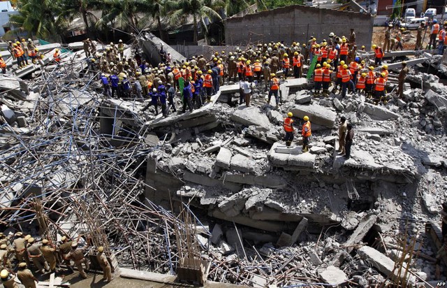 Nhân viên cứu hộ tìm kiếm những người sống sót trong đống đổ nát của tòa nhà 11 tầng bị sập ở thị trấn Porur, Ấn Độ.