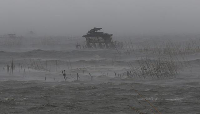 Chòi của ngư dân xiêu vẹo vì gió mạnh, khi siêu bão Thần Sấm đổ bộ vào thị trấn ven biển Bacoor, Philippines.