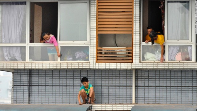 Một cậu bé 12 tuổi ngồi trốn ngoài cửa sổ của căn hộ trên tầng 11 ở thành phố Nghi Tân, Trung Quốc. Cậu bé trốn do sợ mẹ phạt vì cậu không làm bài tập về nhà.