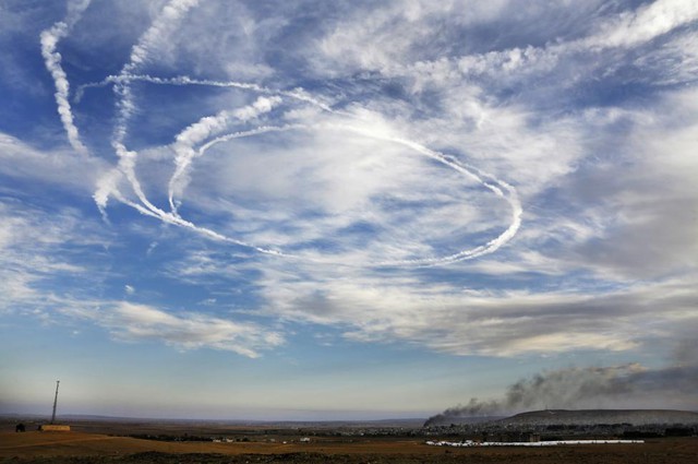 Những vệt khói của máy bay chiến đấu trên bầu trời sau một cuộc không kích tại thị trấn Kobani, Syria.