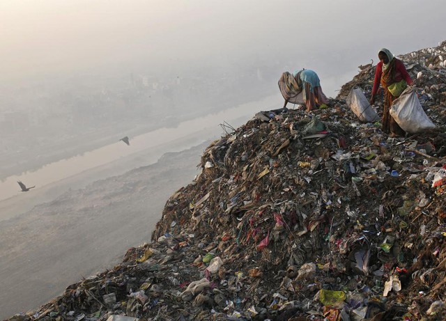 Những người phụ nữ thu lượm đồ có thể tái chế tại một bãi rác ở New Delhi, Ấn Độ.