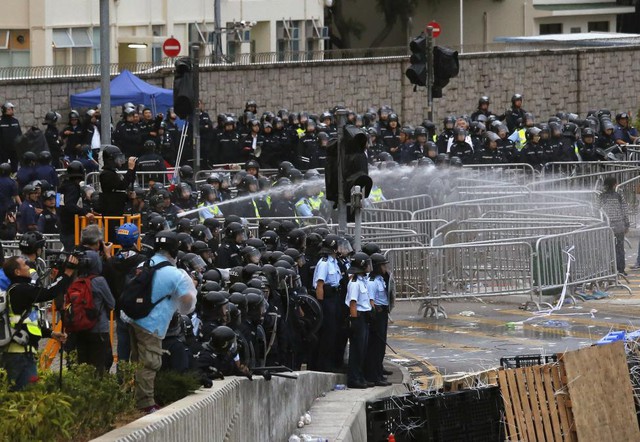 Cảnh sát chống bạo động sử dụng vòi rồng phun nước để giải tán người biểu tình trong cuộc đụng độ bên ngoài tòa nhà thị chính ở Hong Kong.