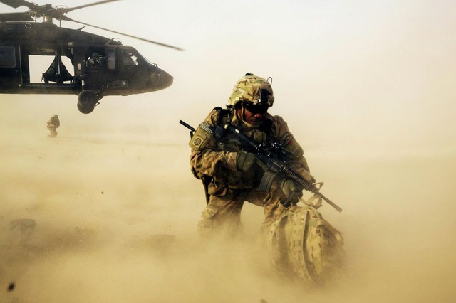 Binh sĩ Mỹ bảo vệ mình khỏi cát bụi sau khi được triển khai từ một trực thăng UH-60 Blackhawk tại tỉnh Nangarhar, Afghanistan.