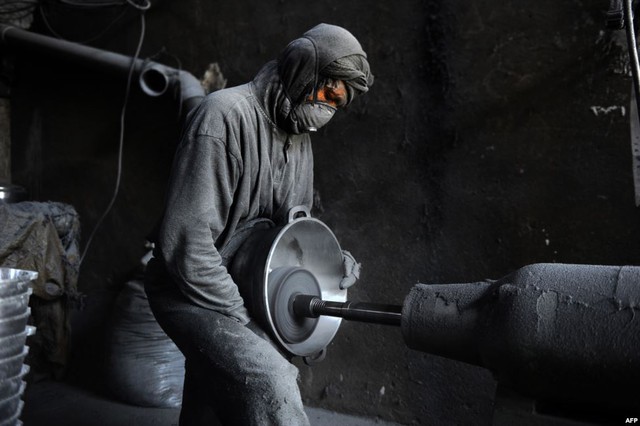 Công nhân đánh bóng nồi kim loại tại một xưởng nhôm ở Herat, Afghanistan.