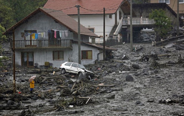 Một người đàn ông đứng nhìn hiện trường đầy bùn đất sau trận lở đất do nước lũ ở Zenica, Bosnia.