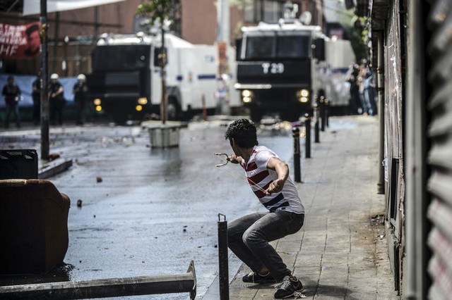 Một thanh niên sử dụng súng cao su bắn đá vào cảnh sát chống bạo động ở Istanbul, Thổ Nhĩ Kỳ.
