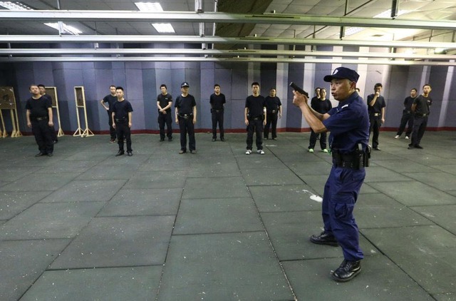 Một cảnh sát hướng dẫn kỹ năng bắn súng cho các học viên tại thành phố Toại Ninh, tỉnh Tứ Xuyên, Trung Quốc.