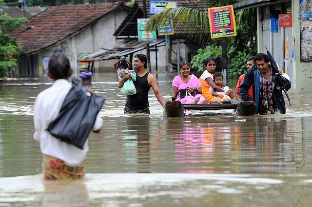 Người dân đi qua đường ngập lụt tại Welipanna, Sri Lanka.