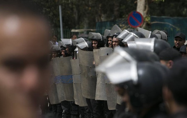 Cảnh sát chống bạo động lập hàng rào ngăn chặn sinh viên biểu tình trước đại học Cairo, Ai CẬp.