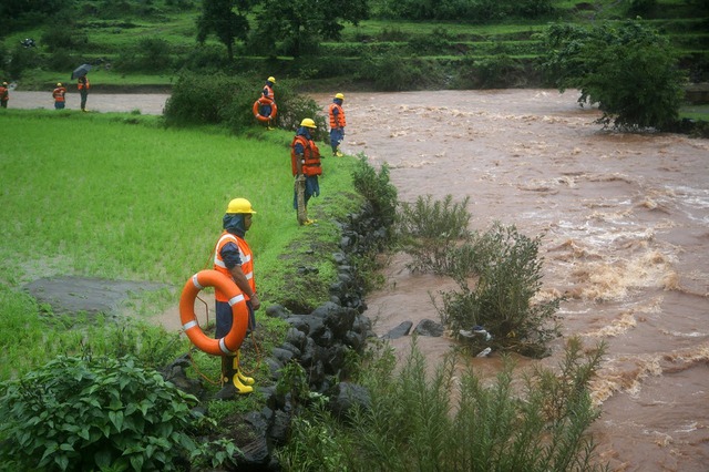 Đội cứu hộ thảm họa tìm kiếm thi thể dưới sông sau vụ lở đất ở Maharashtra, Ấn Độ.