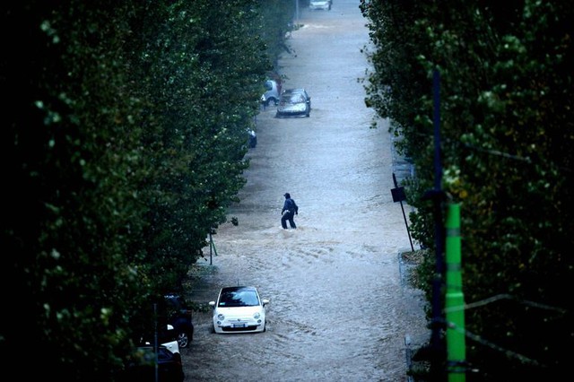 Người đàn ông lội trên đường phố ngập lụt, sau khi sông Seveso bị vỡ bờ đoạn chạy qua thành phố Milan, Italia.