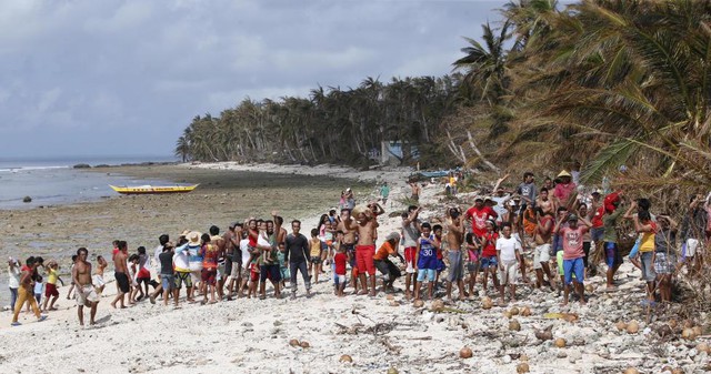 Các nạn nhân của siêu bão Hagupit chờ hàng hóa cứu trợ trên một bãi biển ở Dolores, miền trung Philippines.