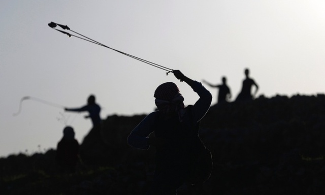 Một người biểu tình Palestine sử dụng súng cao su để quăng đá về phía cảnh sát Israel tại thành phố Ramallah, Bờ Tây.