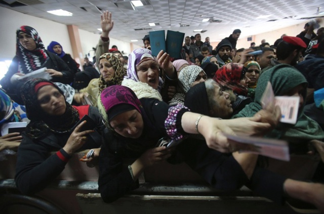 Những phụ nữ người Palestine đưa hộ chiếu của họ, trong khi xếp hàng xin phép vào Ai Cập qua cửa khẩu Rafah.