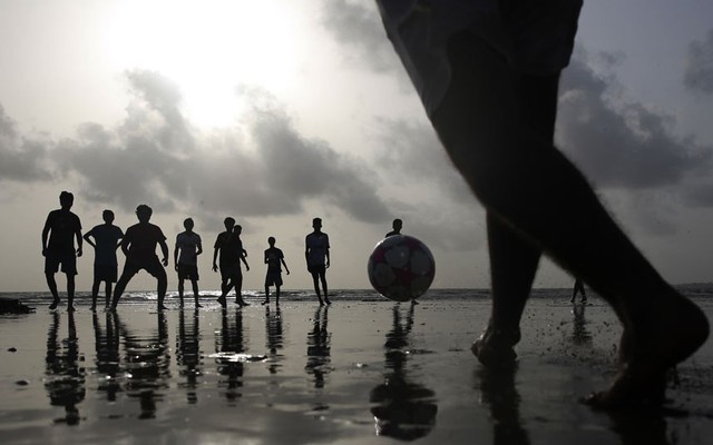 Trẻ em chơi bóng đá trên một bãi biển ở Mumbai, Ấn Độ.