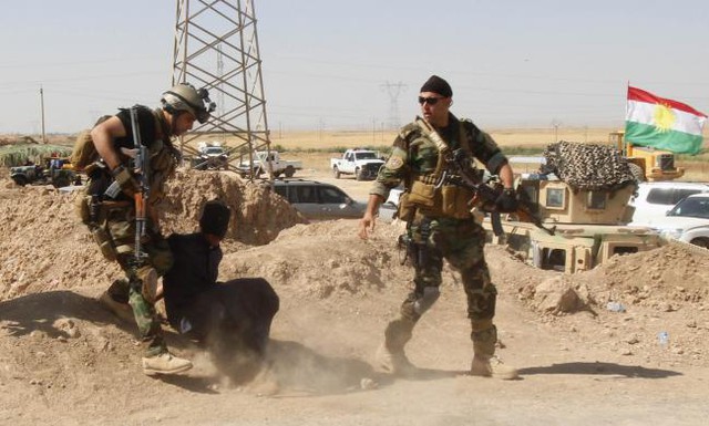 Các thành viên của lực lượng an ninh người Kurd bắt giữ một người đàn ông tình nghi là chiến binh của nhóm phiến quân ISIS ở ngoại ô Kirkuk, Iraq.