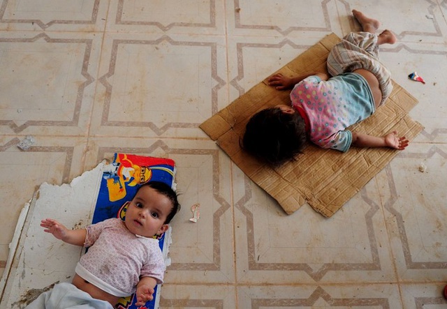 Những đứa trẻ nằm vạ vật trên sàn của một trại tị nạn gần thành phố Mosul, Iraq. 
