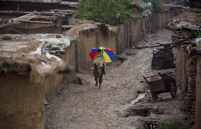 Một cậu bé đi dưới mưa trong tại tị nạn dành cho những người  Afghanistan ở Islamabad, Pakistan.