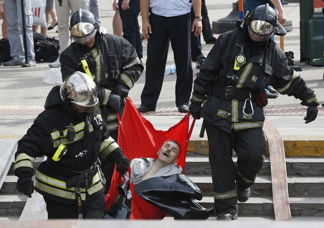 Lực lượng cứu hộ và y tế đưa một hành khách bị thương khỏi hiện trường vụ tàu điện ngầm trật đường ray ở thủ đô Moscow, Nga, khiến ít nhất 15 người thiệt mạng và 160 người bị thương.