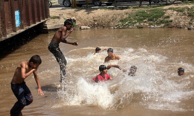 Trẻ em tắm dưới một con kênh ở Lahore, Pakistan. Nhiệt độ tại một số vùng ở Pakistan đã tăng lên hơn 40 độ C.