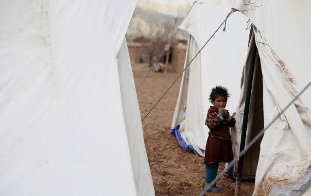 Một em bé mất nhà cửa đứng bên ngoài lều tạm ở tỉnh Bamyan, Afghanistan.