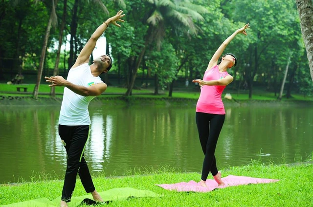 Hạ Vy cùng thầy giáo Ấn Độ trong buổi tập Yoga ngoài trời.
